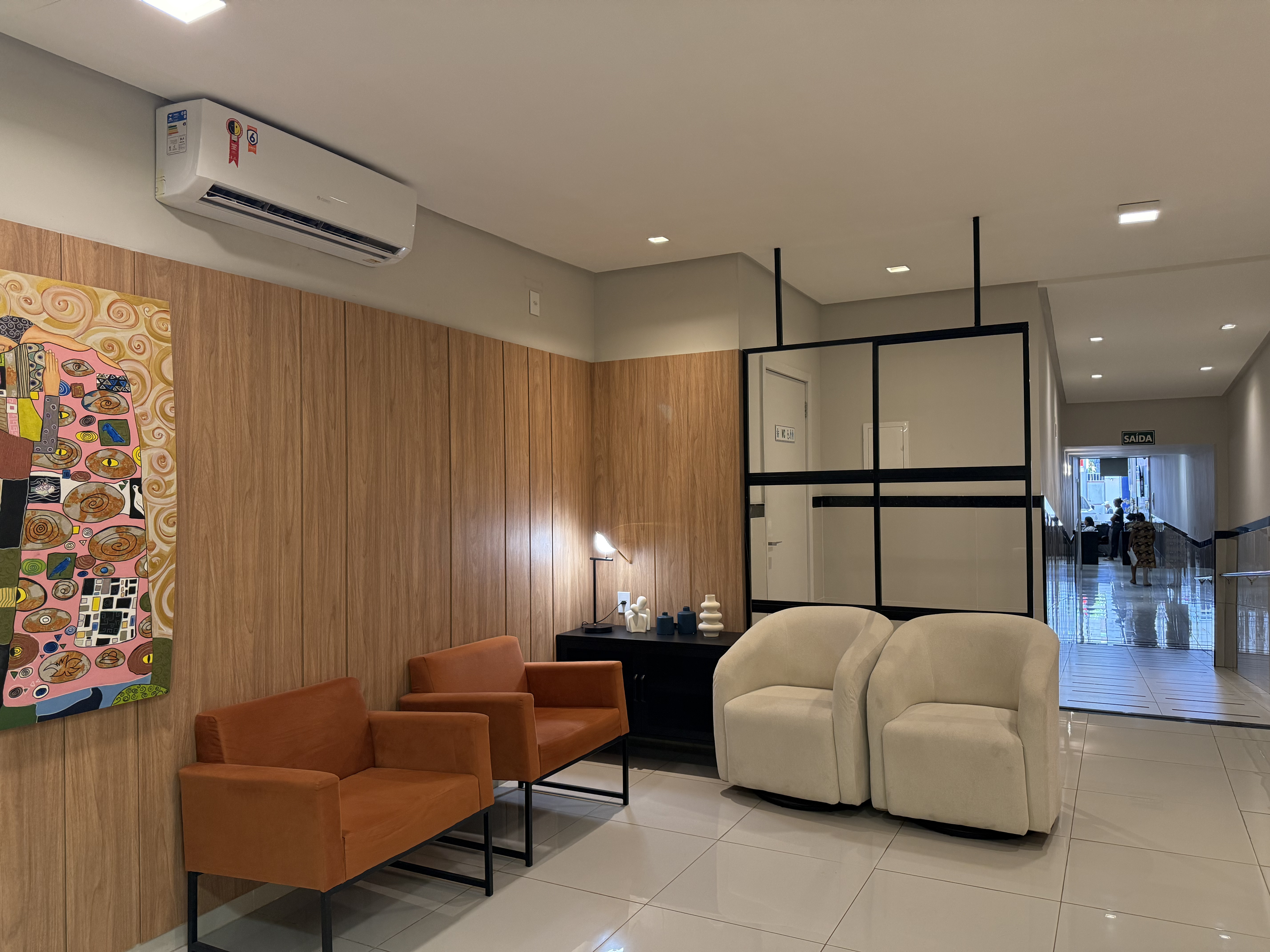 Ambiente moderno com poltronas laranja e arte contemporânea