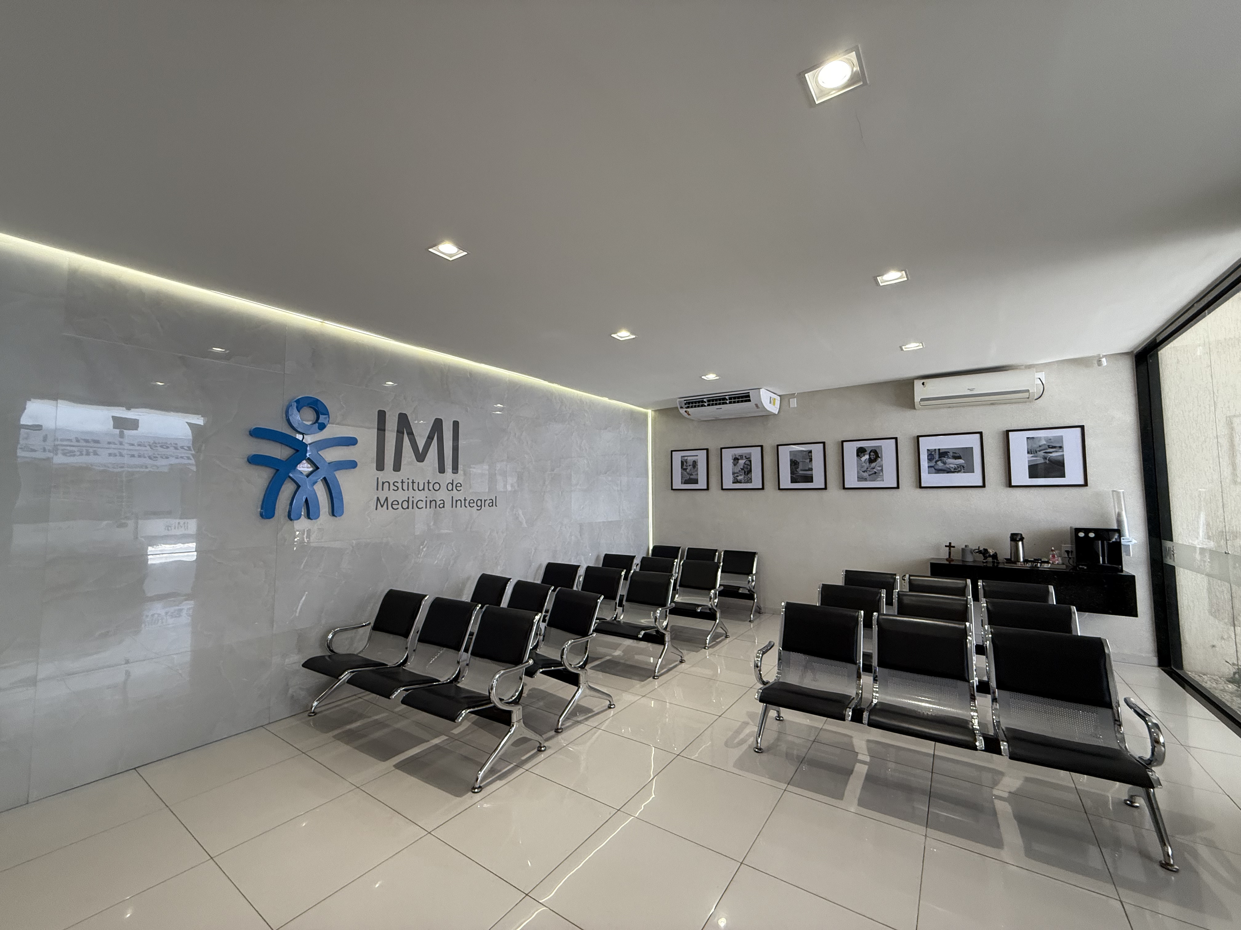 Área de espera com logotipo IMI em 3D e cadeiras modernas
